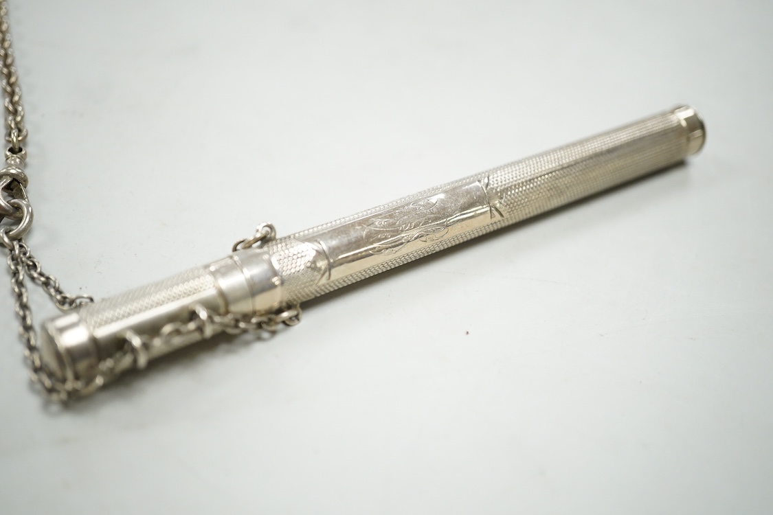 An Edwardian pierced silver chatelaine, by Samuel Jacob, London, 1902, with three accoutrements to include two silver cases and a enamelled fob watch, overall length 34cm.